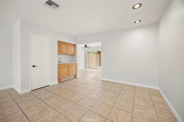empty room featuring light tile patterned floors, a sink, visible vents, and recessed lighting
