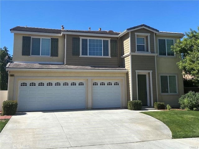 view of front of house with a garage, driveway, and stucco siding