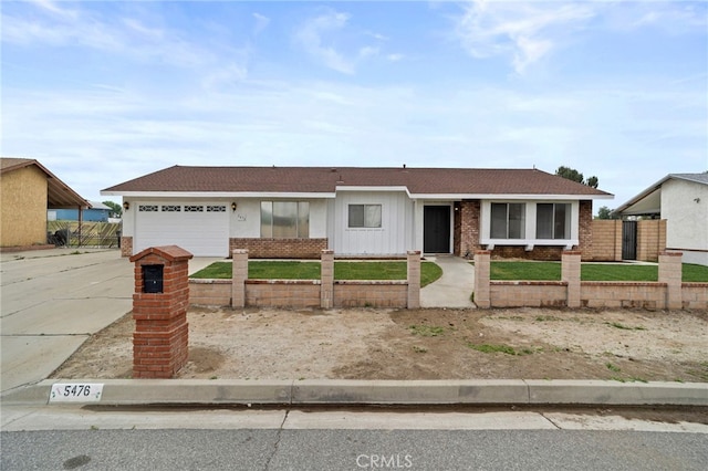 5476 Trail Canyon Dr, Jurupa Valley, CA 91752 - ranch-style house with driveway, brick siding, fence private yard, an attached garage, and board and batten siding