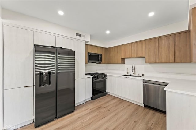 600 W Stocker St Unit 303, Glendale, CA 91202 - kitchen with black appliances, a sink, light countertops, light wood-type flooring, and recessed lighting