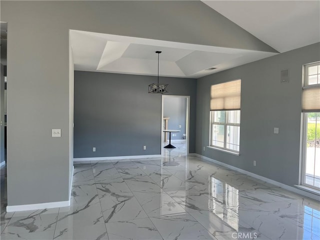 interior space featuring a raised ceiling, marble finish floor, baseboards, and an inviting chandelier