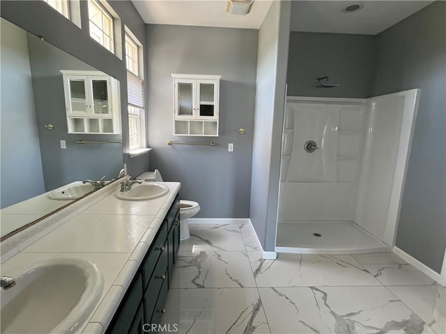 full bath featuring marble finish floor, baseboards, and a sink