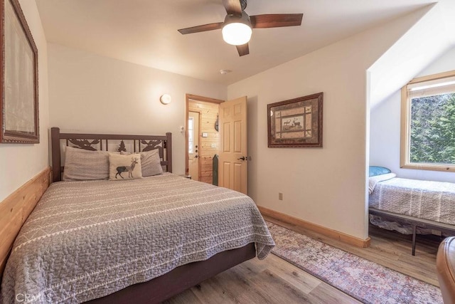 bedroom featuring wood finished floors, baseboards, and ceiling fan