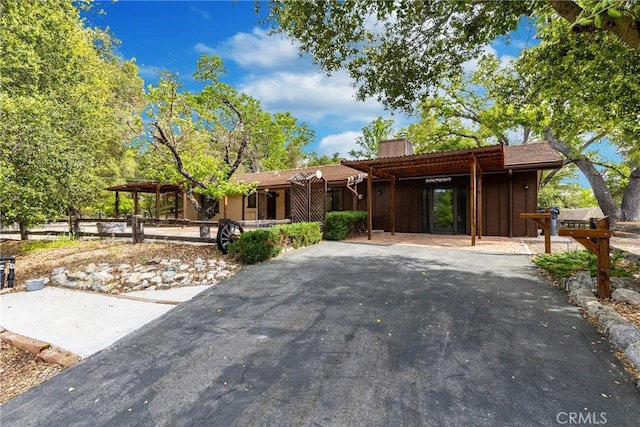 view of front facade featuring fence, a carport, and driveway