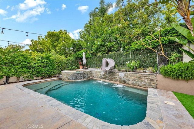 view of pool featuring a fenced backyard, a patio area, a water slide, and a pool with connected hot tub