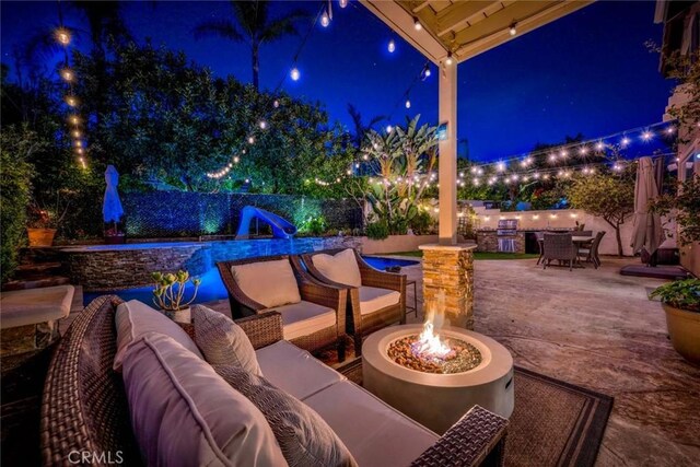 patio at twilight with an outdoor pool, outdoor dining space, a fenced backyard, and an outdoor living space with a fire pit