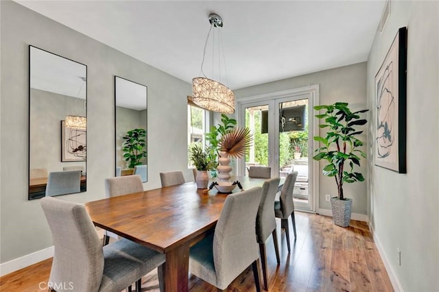 dining area with baseboards and light wood-style flooring