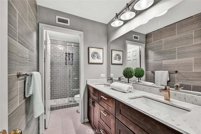 bathroom featuring a sink, a stall shower, and visible vents