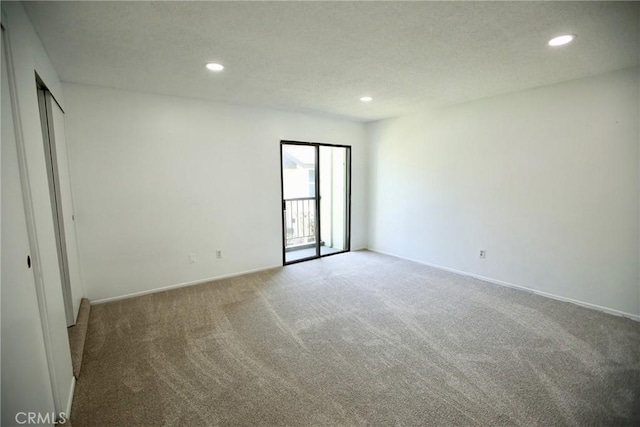carpeted spare room with baseboards, recessed lighting, and a textured ceiling