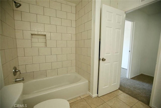 bathroom featuring tile patterned flooring, baseboards, shower / tub combination, and toilet