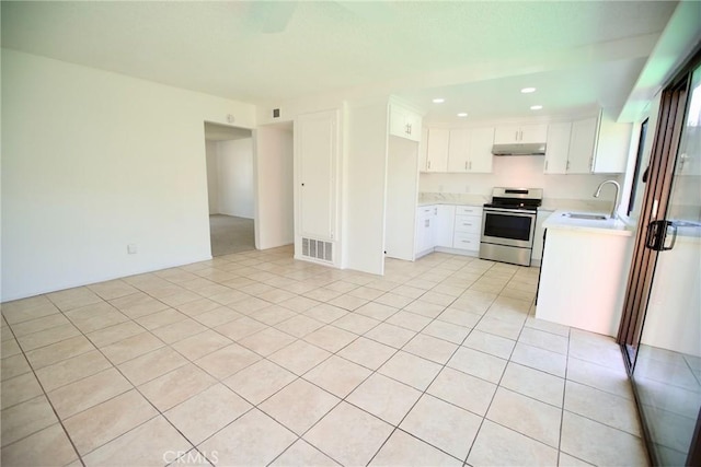 kitchen with a sink, stainless steel electric range oven, visible vents, light countertops, and under cabinet range hood