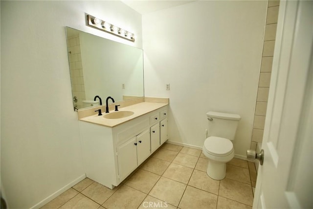 bathroom with baseboards, vanity, tile patterned flooring, and toilet
