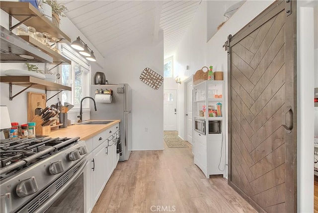 346 San Bernardino Ave, Sugarloaf, CA 92386 - kitchen featuring a barn door, white cabinets, light wood finished floors, open shelves, and gas stove