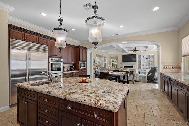 2831 Shenandoah Dr, Chula Vista, CA 91914 - kitchen featuring built in appliances, arched walkways, a sink, stone tile flooring, and recessed lighting