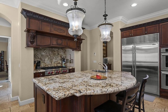 2831 Shenandoah Dr, Chula Vista, CA 91914 - kitchen featuring stainless steel appliances, a sink, stone tile flooring, arched walkways, and decorative backsplash