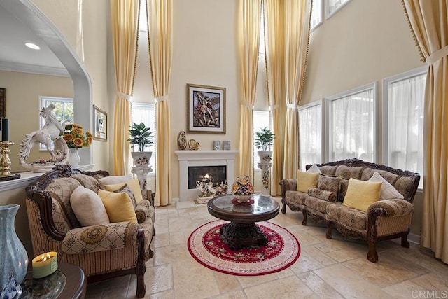 2831 Shenandoah Dr, Chula Vista, CA 91914 - sitting room with a high ceiling, stone tile floors, crown molding, a lit fireplace, and arched walkways