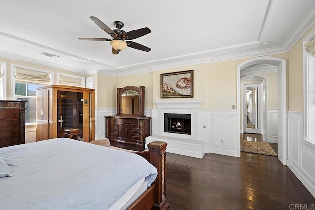2831 Shenandoah Dr, Chula Vista, CA 91914 - bedroom with a decorative wall, dark wood-style floors, a lit fireplace, wainscoting, and crown molding
