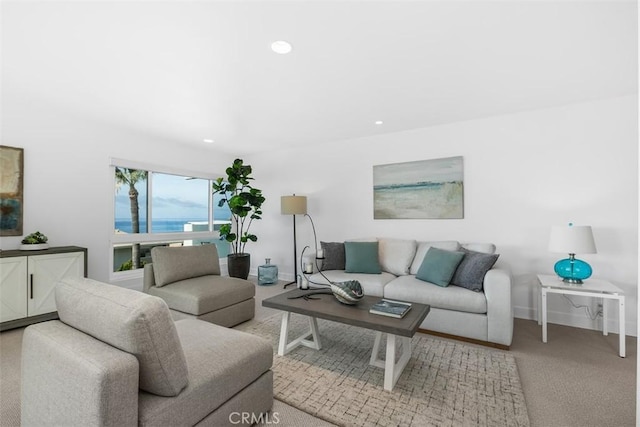 living area with baseboards, recessed lighting, light carpet, and a water view