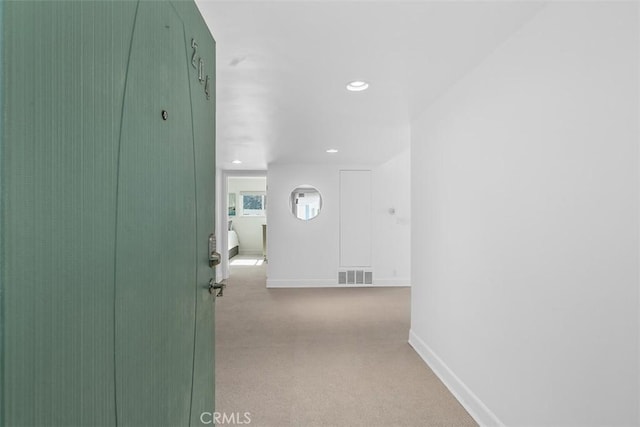 hallway featuring recessed lighting, visible vents, baseboards, and light carpet