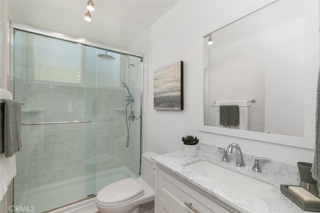full bathroom with a shower stall, toilet, and vanity