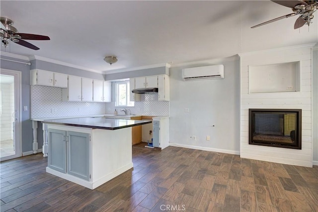 8920 Arcade Rd, Atascadero, CA 93422 - kitchen featuring a wall mounted AC, ceiling fan, dark wood-style floors, decorative backsplash, and crown molding