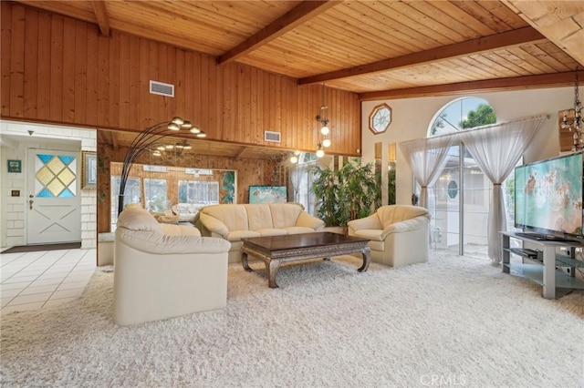 living area featuring wood ceiling, wooden walls, visible vents, and beam ceiling