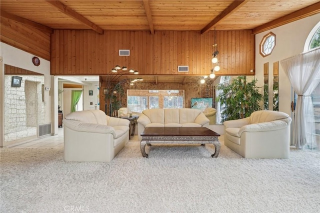 living area featuring beam ceiling, wood ceiling, and visible vents