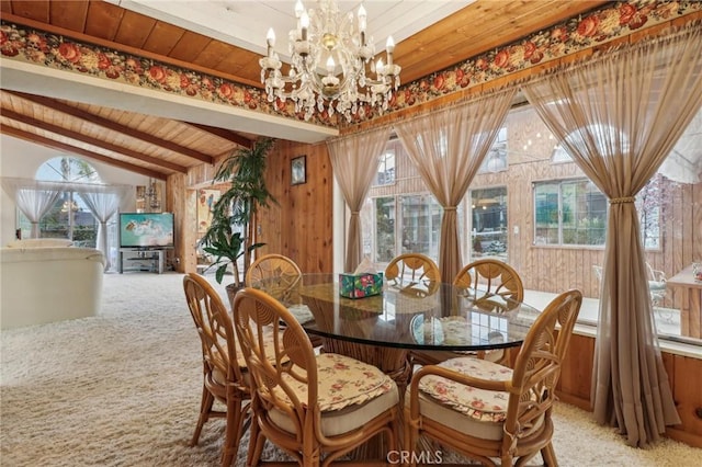dining area with wood ceiling, an inviting chandelier, wood walls, and plenty of natural light