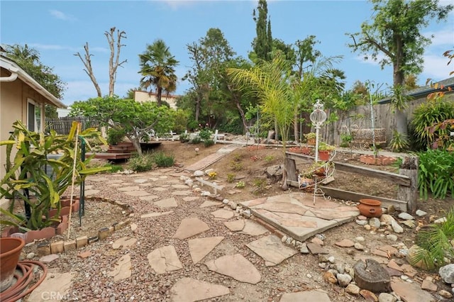 view of yard featuring a fenced backyard, a garden, and a patio