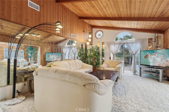 living room with carpet flooring, visible vents, beamed ceiling, wood walls, and wooden ceiling