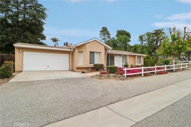 single story home featuring an attached garage, driveway, and fence private yard
