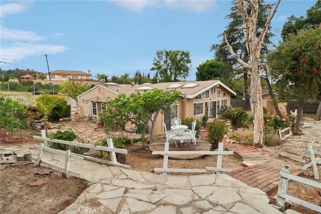view of front of property featuring a patio and fence