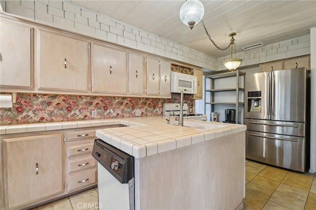 kitchen featuring visible vents, light brown cabinets, white appliances, and light tile patterned floors