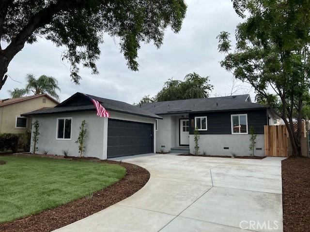 ranch-style home with crawl space, a front lawn, driveway, fence, and a garage