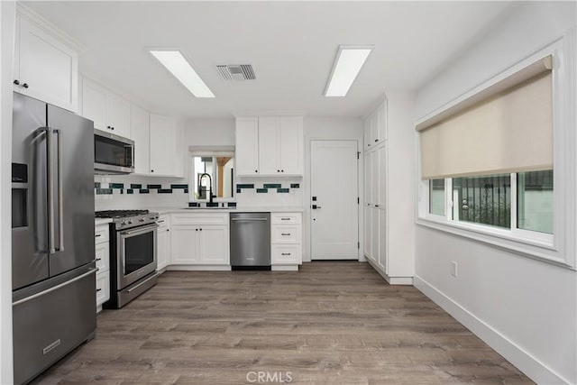6130 Myrtle Ave, Long Beach, CA 90805 - kitchen featuring a sink, appliances with stainless steel finishes, white cabinets, and visible vents