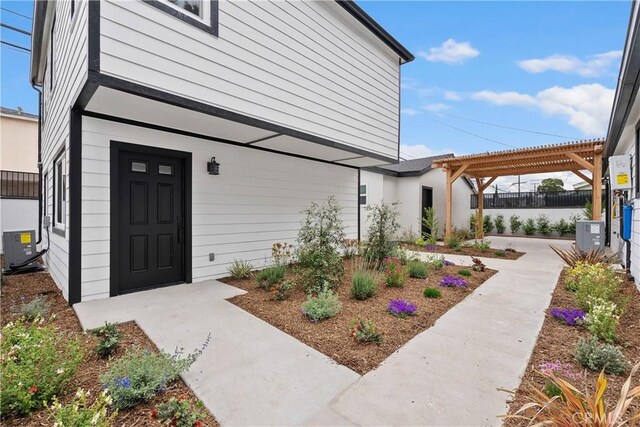 6130 Myrtle Ave, Long Beach, CA 90805 - view of exterior entry featuring a pergola, fence, and central AC unit
