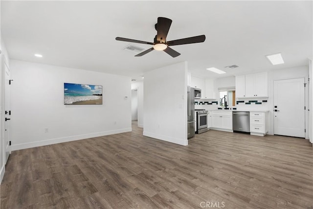 6130 Myrtle Ave, Long Beach, CA 90805 - unfurnished living room with a ceiling fan, visible vents, wood finished floors, a sink, and baseboards