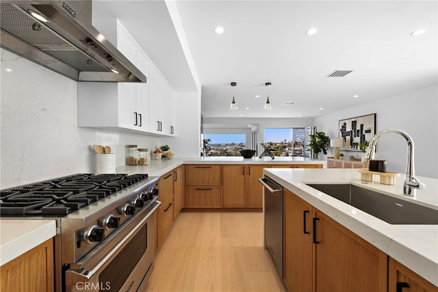 309 Carnation Ave Unit 4, Corona Del Mar, CA 92625 - kitchen featuring wall chimney exhaust hood, appliances with stainless steel finishes, light wood-style flooring, recessed lighting, and decorative light fixtures
