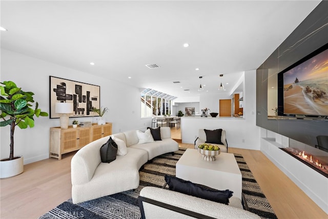 309 Carnation Ave Unit 4, Corona Del Mar, CA 92625 - living room featuring light wood finished floors, a glass covered fireplace, and recessed lighting