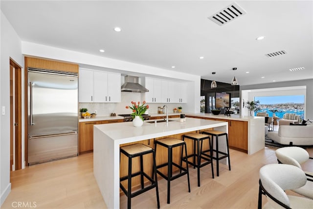 309 Carnation Ave Unit 4, Corona Del Mar, CA 92625 - kitchen with built in refrigerator, wall chimney range hood, recessed lighting, light countertops, and light wood-style flooring