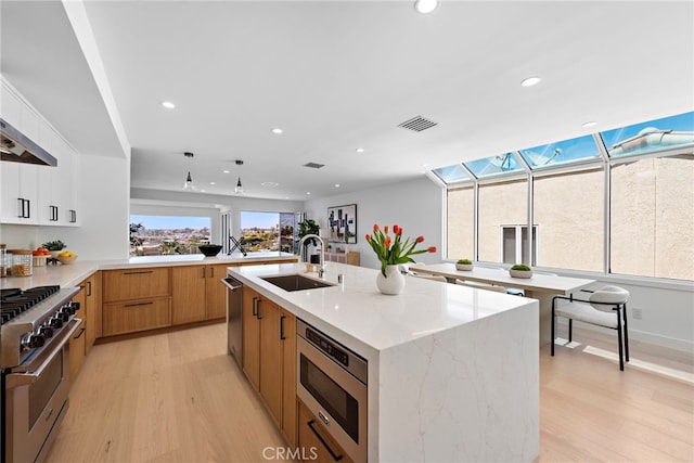 309 Carnation Ave Unit 4, Corona Del Mar, CA 92625 - kitchen featuring stainless steel appliances, light wood-style floors, recessed lighting, light stone countertops, and modern cabinets