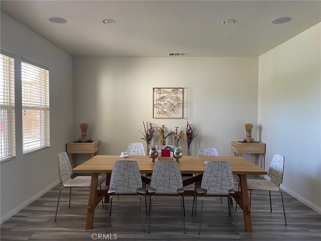 dining room with wood finished floors, visible vents, and baseboards