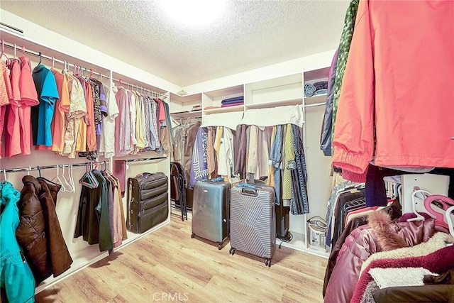walk in closet with wood finished floors