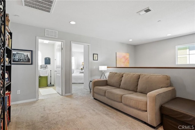 living room featuring light carpet, visible vents, and recessed lighting