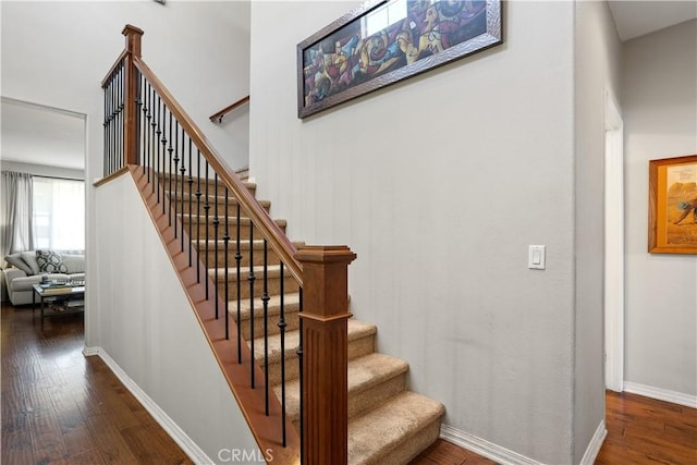 stairs with hardwood / wood-style floors and baseboards