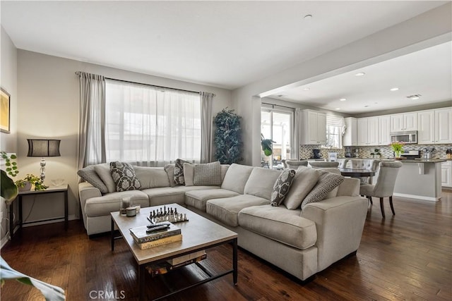 living room featuring baseboards and dark wood-style flooring