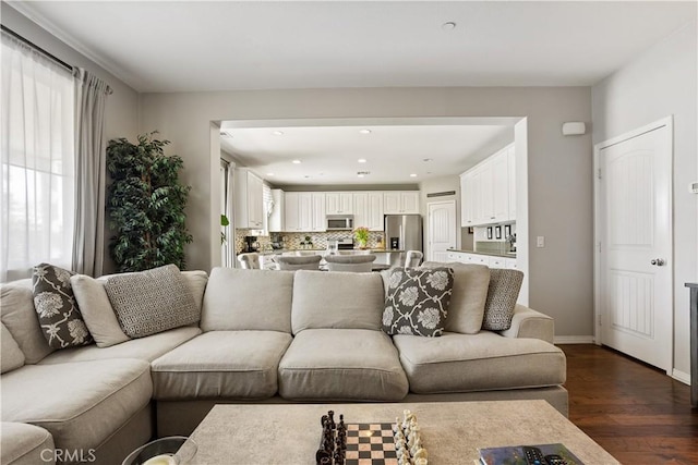 living area featuring baseboards, dark wood-style flooring, and recessed lighting