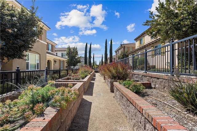 view of yard featuring a residential view, a vegetable garden, and fence