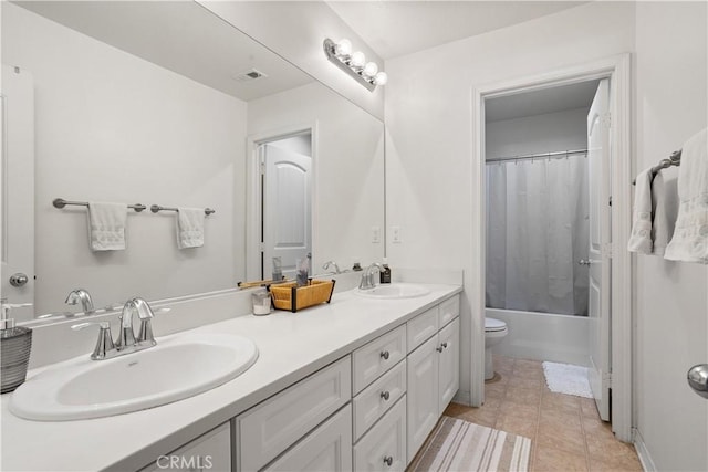 bathroom featuring visible vents, a sink, double vanity, and toilet
