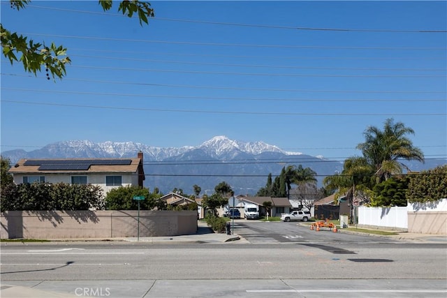 view of street with a residential view, curbs, sidewalks, and a mountain view